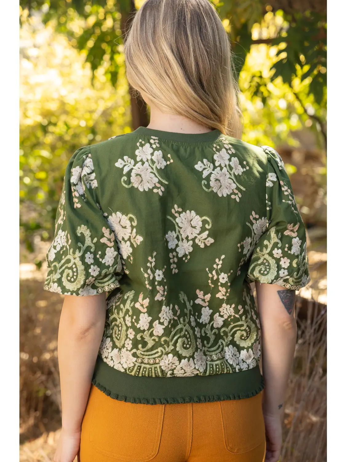 Floral and ruffle detail on green top
