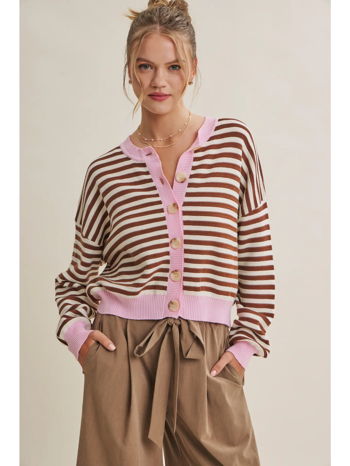 Brown and cream striped cardigan with pink ribbed trim and button front, close-up