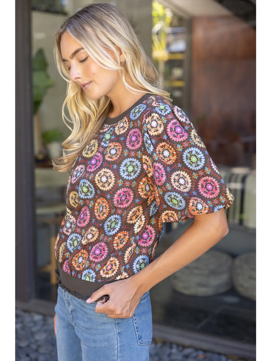 Medallion-print top showing the gathered ruffle hem