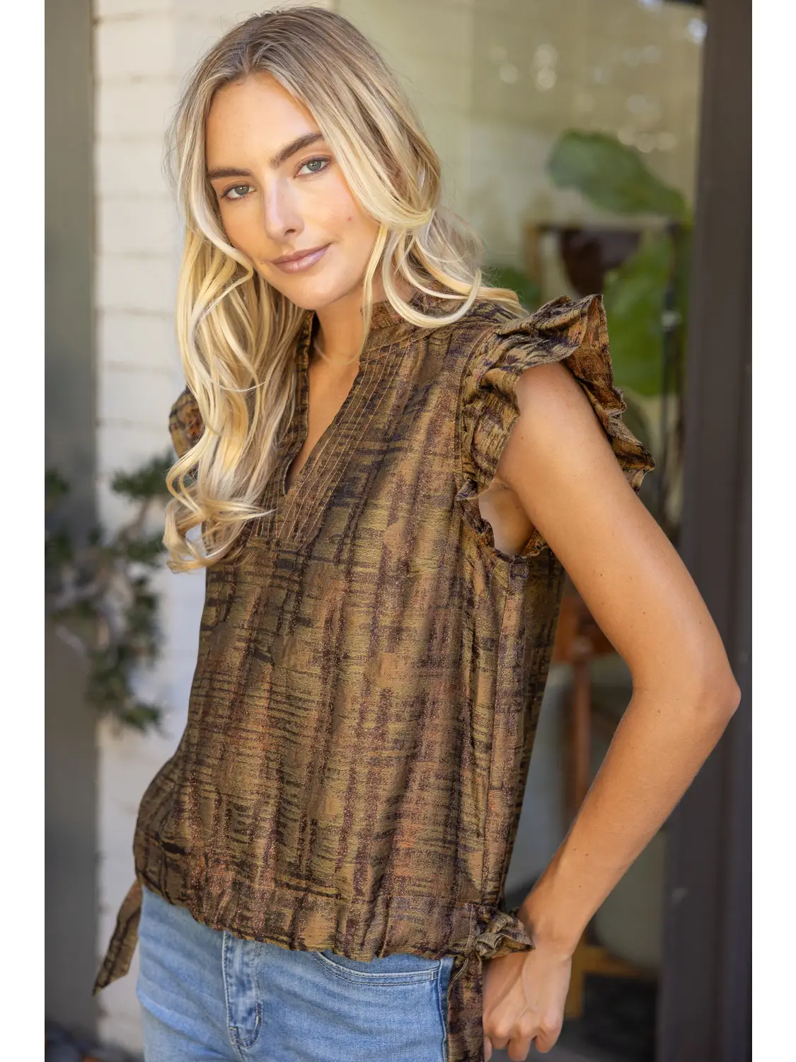 Close view of the metallic plaid texture and flutter sleeves