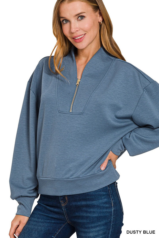 Model wearing dusty-blue scuba half-zip pullover