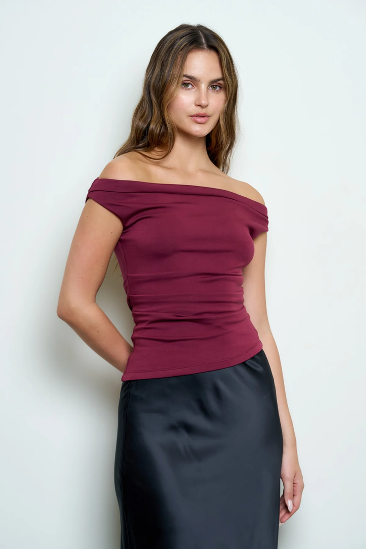 Model wearing burgundy off-shoulder ruched top