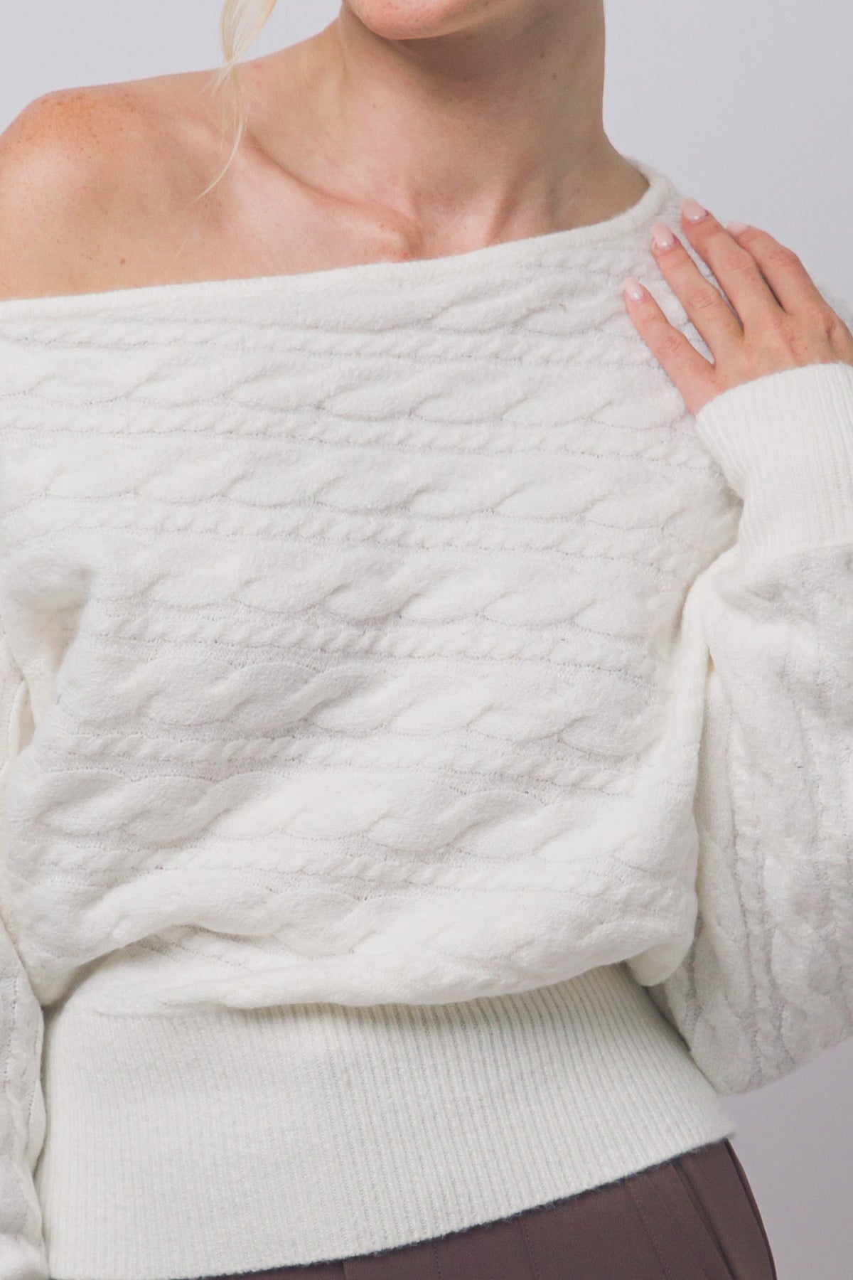 Close-up of cable texture and asymmetric neckline