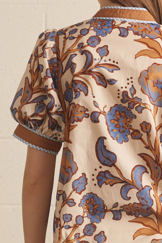 Ivory floral contrast-trim top with a ruffled split neckline and short puff sleeves