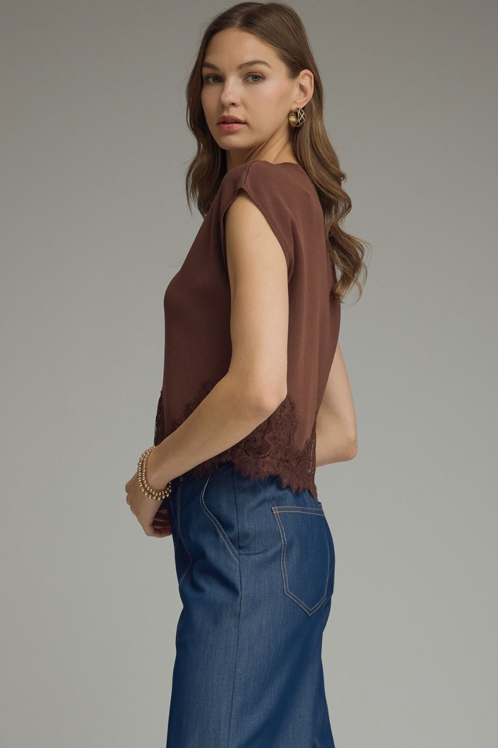 Side view of brown lace-trim knit top showing cap sleeve and relaxed silhouette