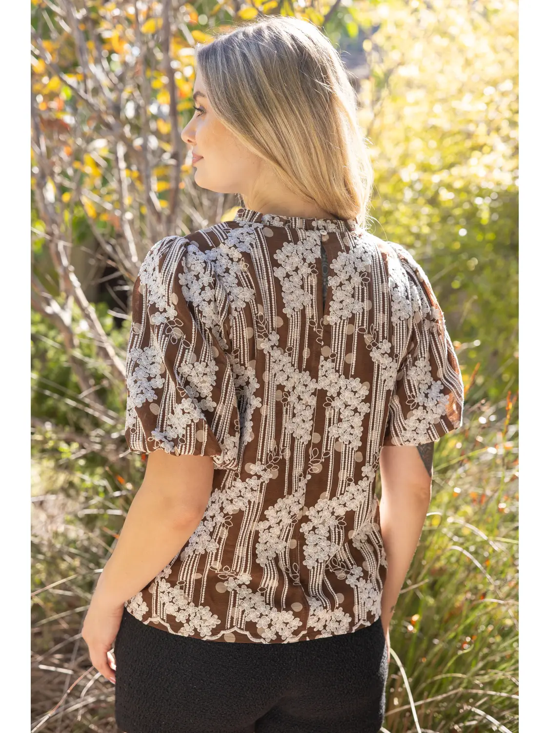 Floral and polka-dot detail on brown chiffon top
