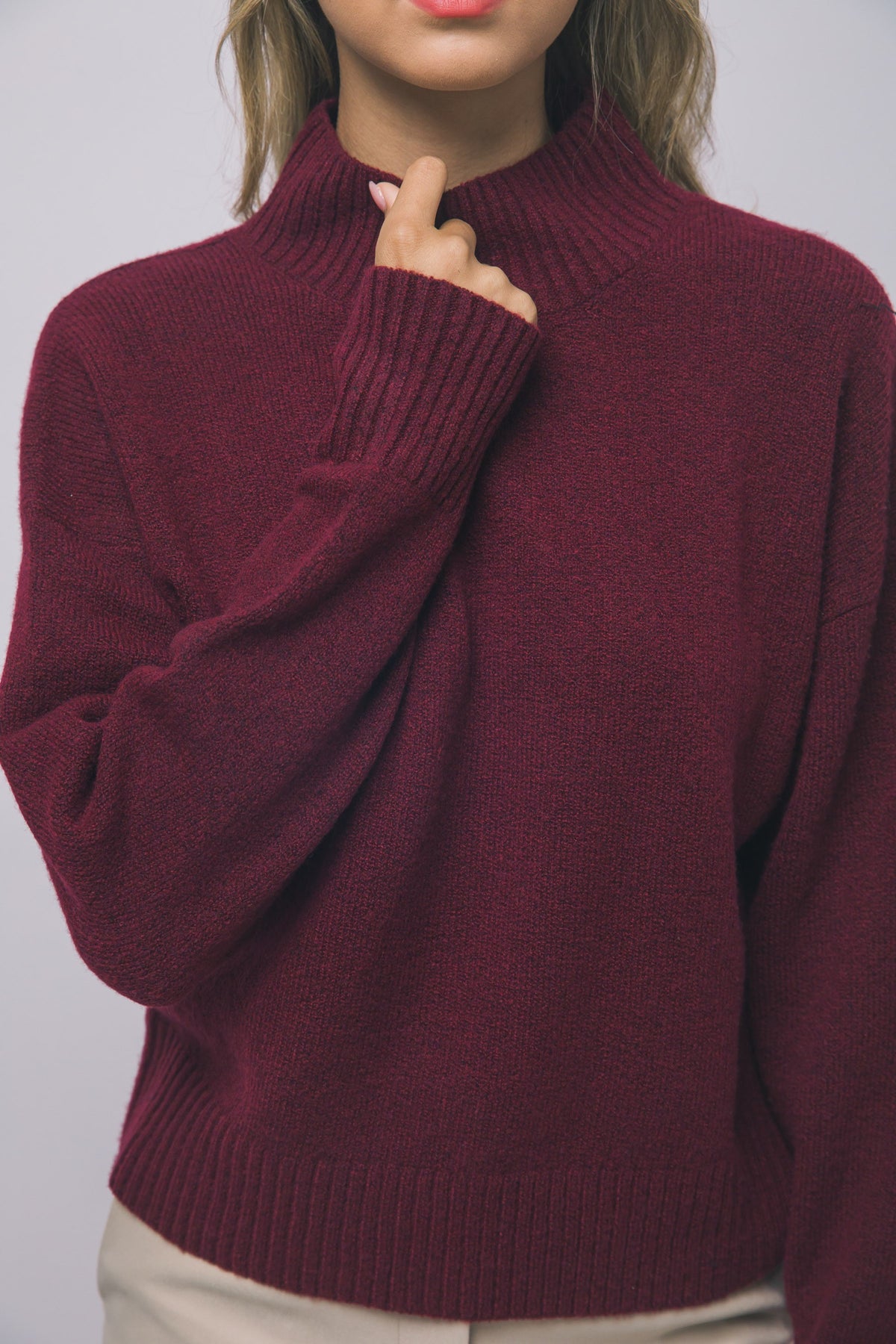 Close-up of red slouchy mock-neck sweater