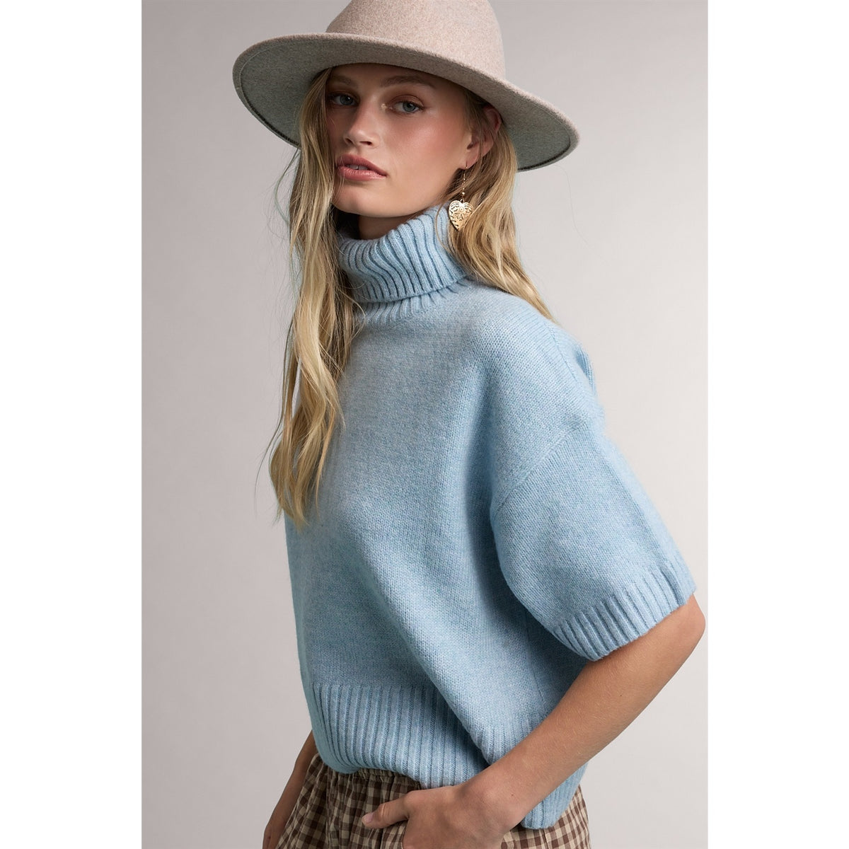 Light blue turtleneck sweater with ribbed trim, side view