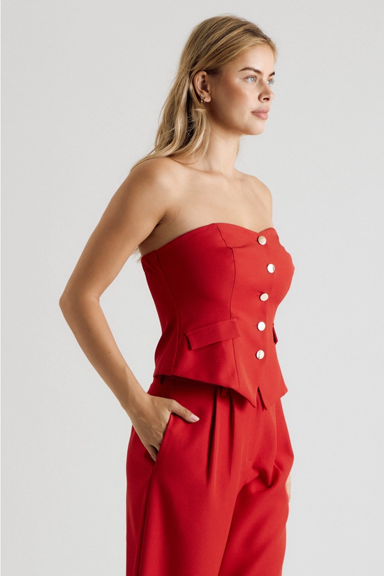 Side view of red strapless vest top and wide-leg trousers
