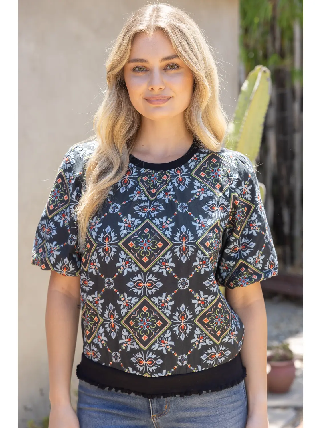 Model wearing the black ornamental tile-print top