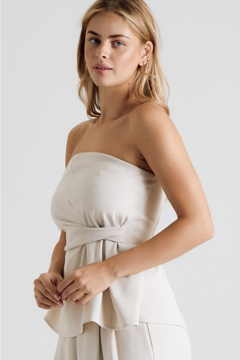 Close-up of cream strapless twist-waist top