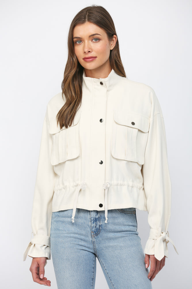 Model wearing ecru drawstring utility jacket