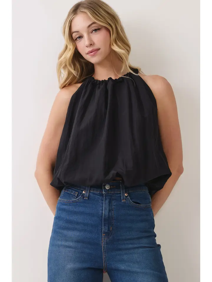 Model wearing black gathered halter balloon top