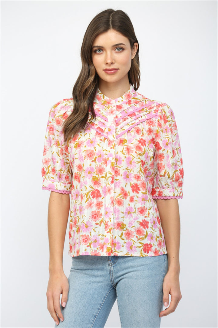 Woman wearing a floral blouse and jeans on a white background
