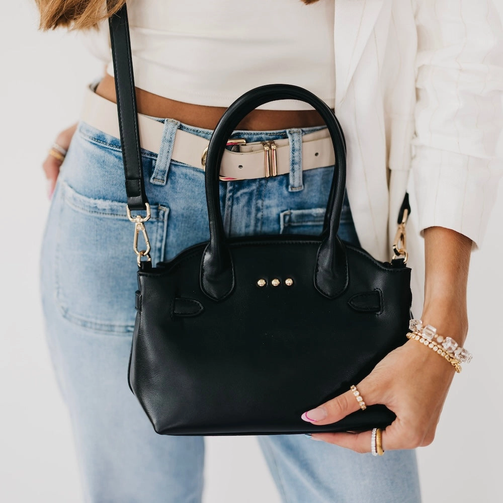 Veronica small tote in black carried by top handles with crossbody strap