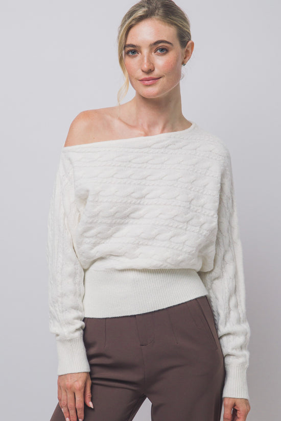 Front view of ivory cable-knit off-shoulder sweater