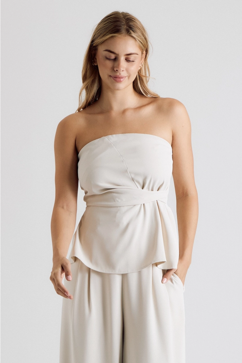 Front view of cream strapless twist-waist top