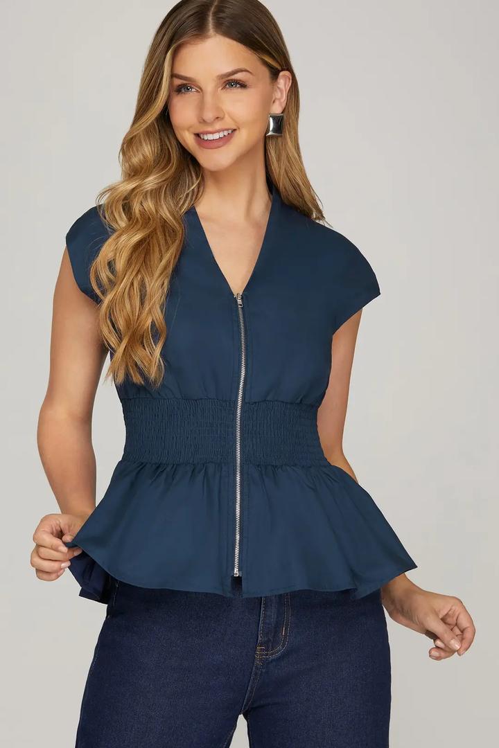 Model wearing navy smocked-waist zip top