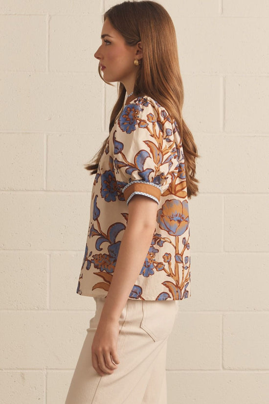 Ivory floral contrast-trim top with a ruffled split neckline and short puff sleeves