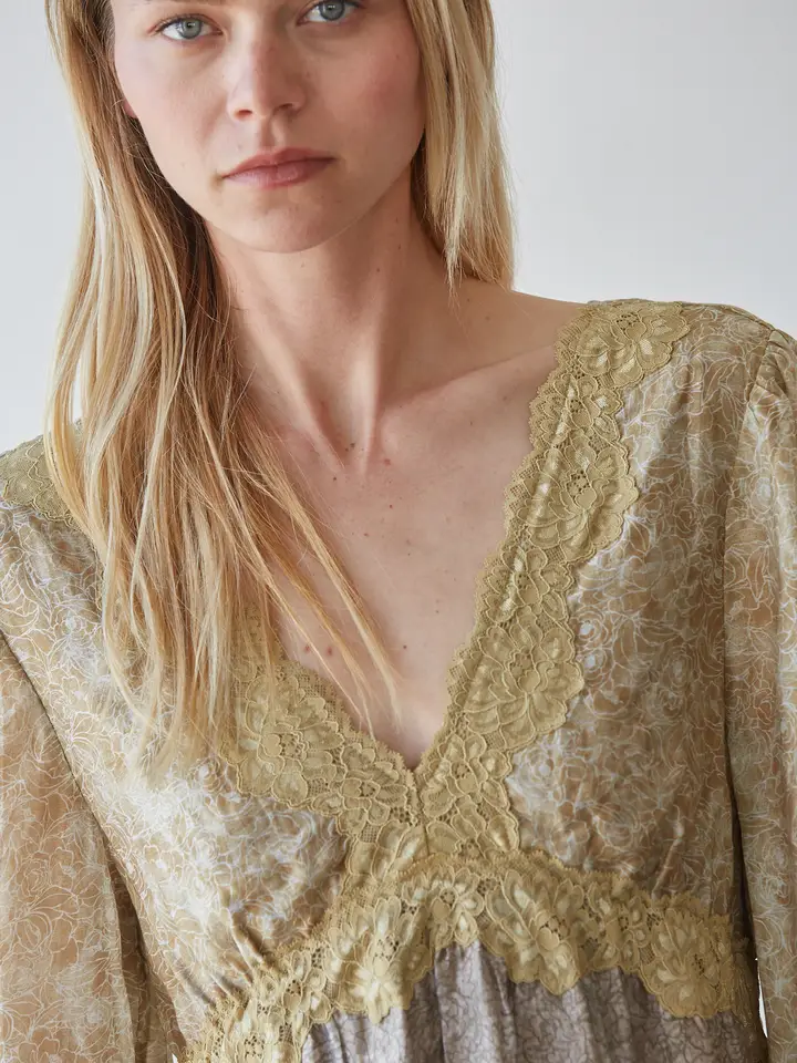 Close-up of lace-trim V-neckline on floral mini dress