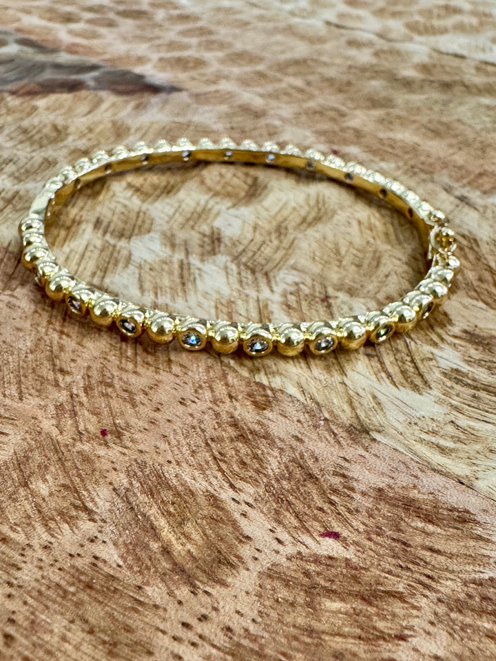 Gold beaded bracelet on a wooden surface
