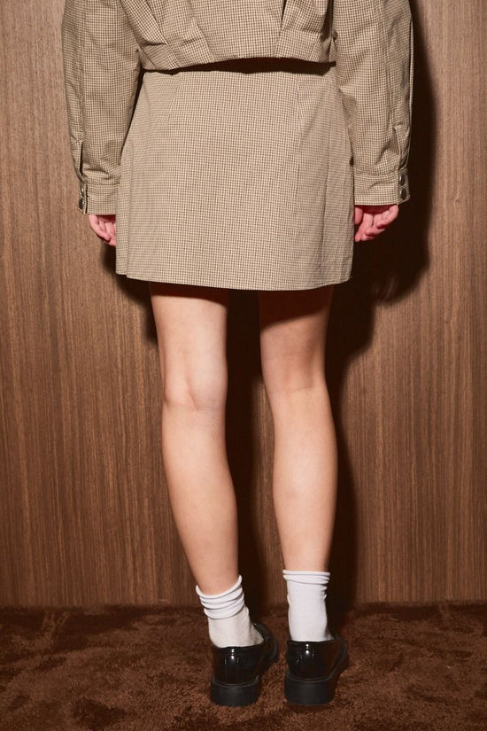 Taupe low-rise plaid mini skirt on model, back view