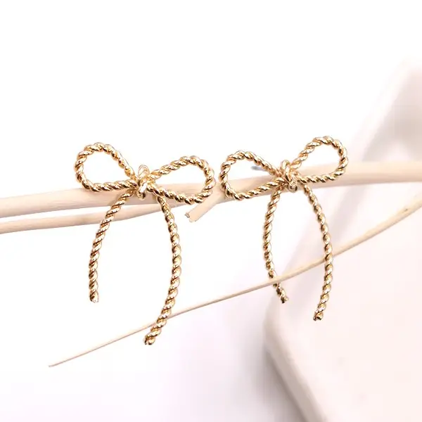 Two gold rope bows tied on thin sticks, decorative accessory.