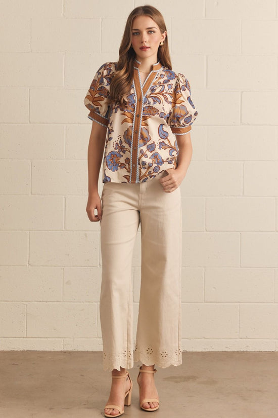 Ivory floral contrast-trim top with a ruffled split neckline and short puff sleeves