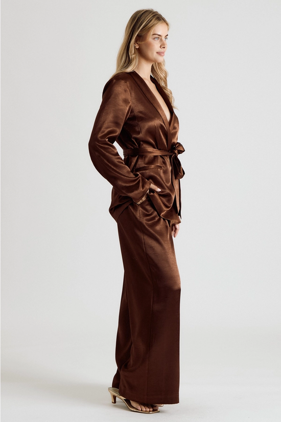 Side view of brown satin blazer styled with matching trousers
